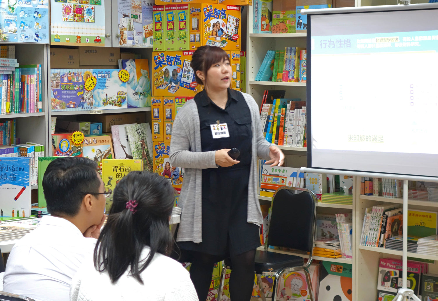 Woman giving educational presentation on children's books and learning games in bookstore