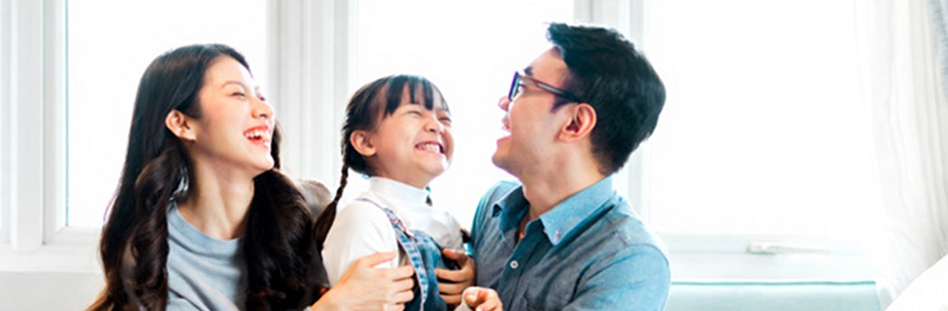 Happy family with parents and child smiling and laughing together indoors