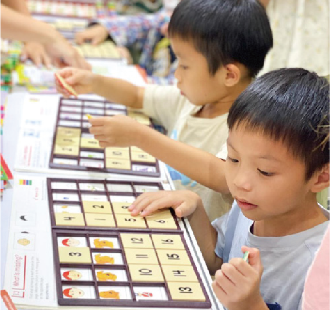 兩位小男孩在桌前一起玩智高FUN遊戲，鍛鍊邏輯思維。