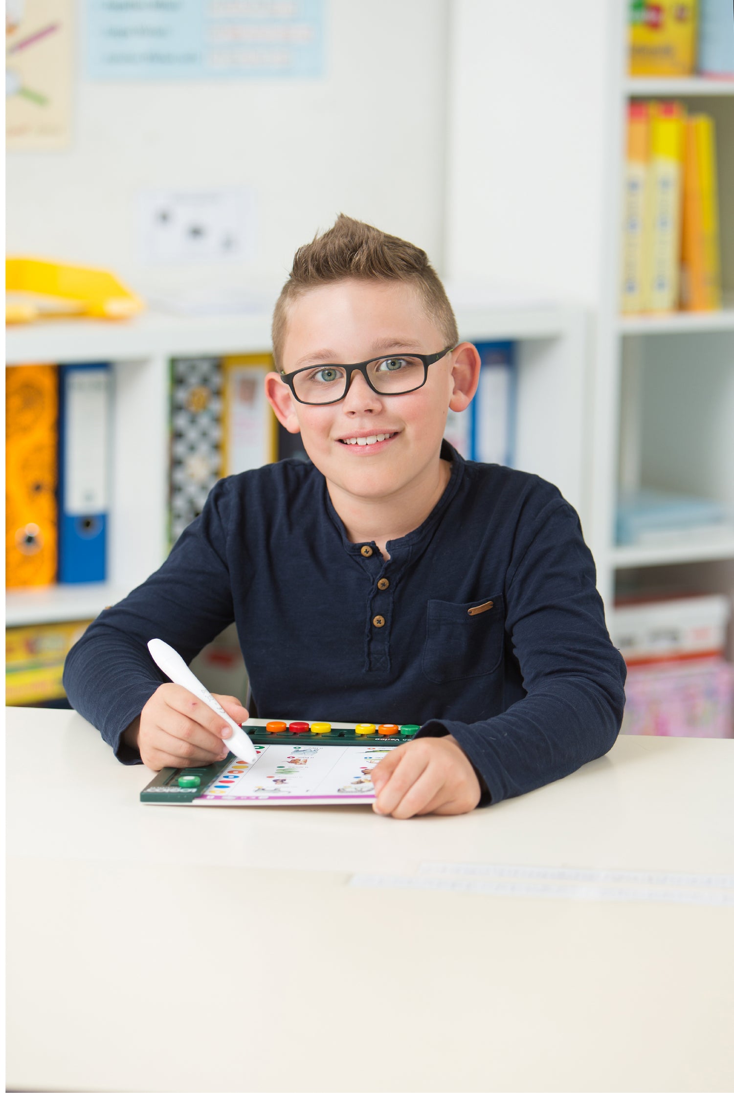 A boy with glasses focused on solving a problem with the LOGICO MAXIMO learning system.