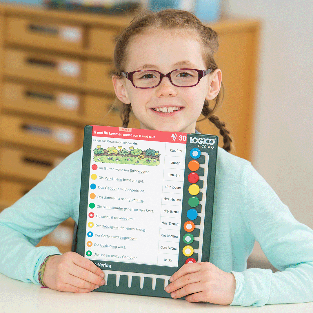 一位戴眼鏡的小女孩，正在桌前專心地玩著樂智高 (LOGICO) PICCOLO 學習遊戲。