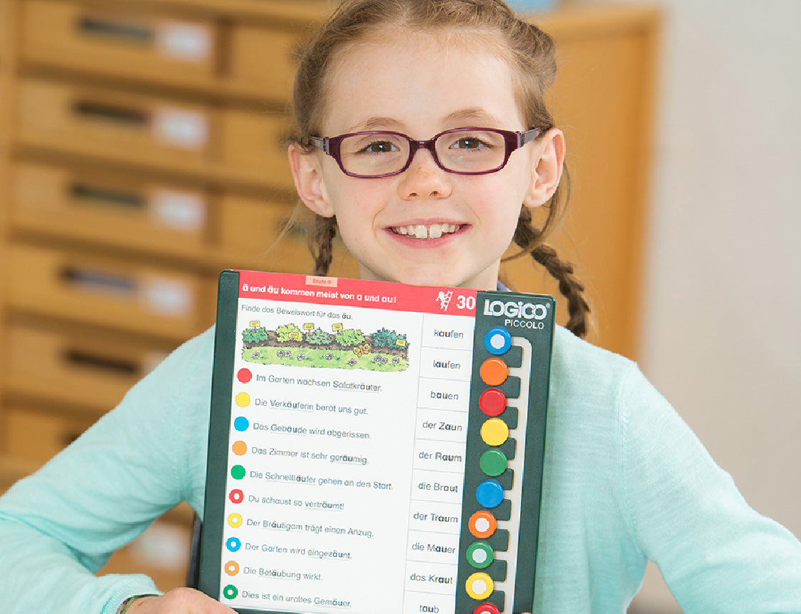 LOGICO PICCOLO feature: Builds Independent Problem-Solving, showing a young girl proudly holding her completed learning board.