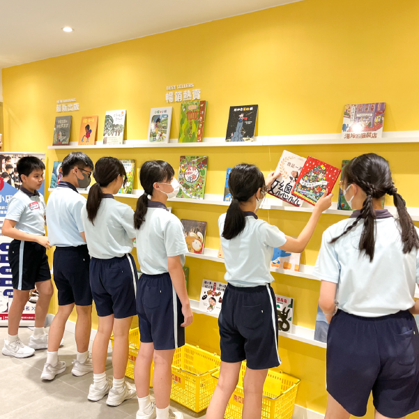 幾位穿著校服的學生在書店內，開心地挑選和閱讀書籍，進行小小店長活動。